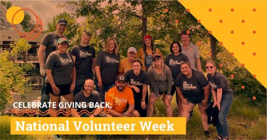 A group of people stand together for a photo outside a building.