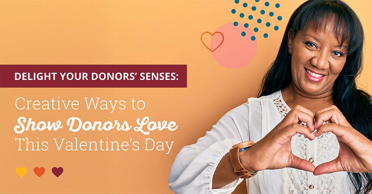 Image of a smiling African American woman with long straight black hair wearing a white blouse and a light brown watch. She is standing in front of an orange background and making a heart shape with her hands. Text on the left side of the graphic says "Delight Your Donors’ Senses: Creative Ways to Show Donors Love This Valentine’s Day".