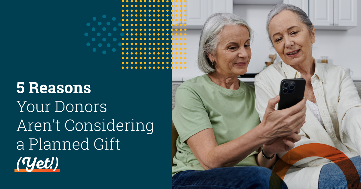 Two senior caucasian women with silver hair wearing casual clothes sitting together. The women with short hair on the left is holding a smartphone and showing an article to the woman next to her. Text on the left side of the image says "5 Reasons Your Donors Aren’t Considering a Planned Gift (Yet!)".